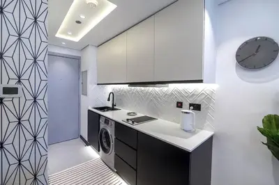 a kitchen with a sink and a clock on a wall at Classy and Bright - Studio - JLT in Dubai
