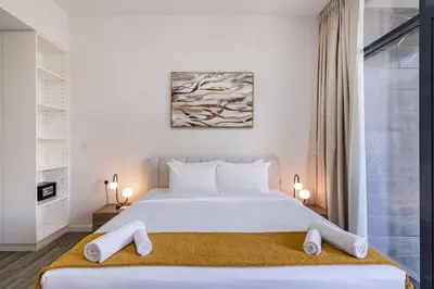 a bedroom with a large white bed with white pillows at Belgravia T2,JVC - 2BR Duplex Apartment - Allsopp&Allsopp in Dubai
