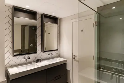 a bathroom with a sink and a glass shower at Belgravia T2,JVC - 2BR Duplex Apartment - Allsopp&Allsopp in Dubai