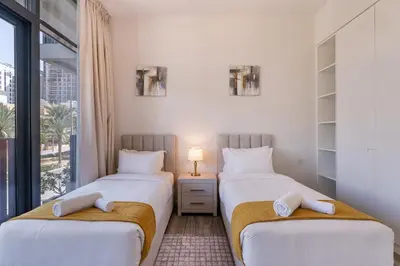 two twin beds in a room with a window at Belgravia T2,JVC - 2BR Duplex Apartment - Allsopp&Allsopp in Dubai