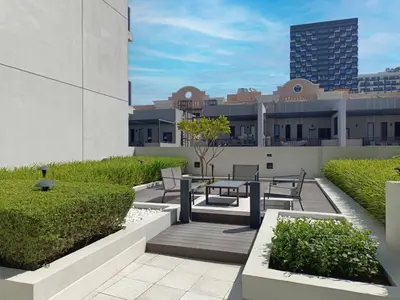 a patio with a table and chairs on top of a building at Belgravia T2,JVC - 2BR Duplex Apartment - Allsopp&Allsopp in Dubai