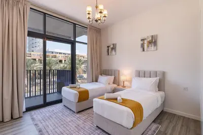 two beds in a room with a large window at Belgravia T2,JVC - 2BR Duplex Apartment - Allsopp&Allsopp in Dubai