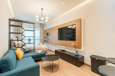a living room with a blue couch and a tv at Stylish and Sleek - Studio - JLT in Dubai