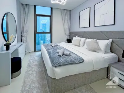 a bedroom with a large bed and a mirror at Burj Crown Luxury 2-Bedroom with Balcony in Dubai