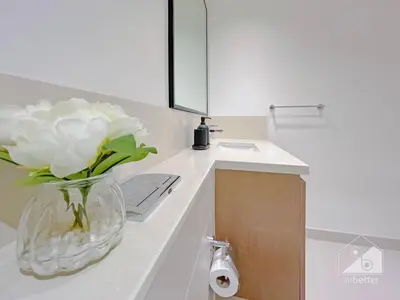 a vase with white flowers on a counter in a bathroom at Burj Crown Luxury 2-Bedroom with Balcony in Dubai