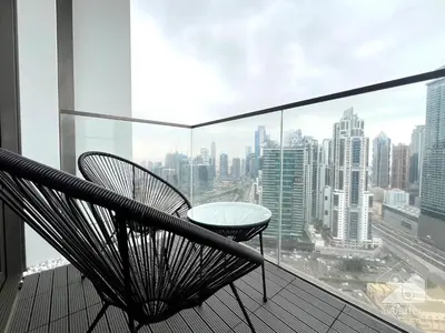 a balcony with a table and chairs and a city at Burj Crown Luxury 2-Bedroom with Balcony in Dubai