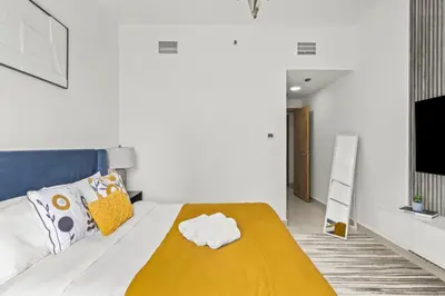 a bedroom with a bed with a yellow blanket at Lavish 2BR with Charming Marina View in Dubai