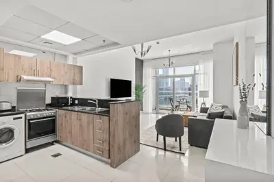 a kitchen and living room with a couch and a table at Lavish 2BR with Charming Marina View in Dubai