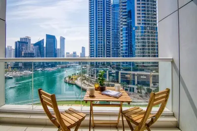 a balcony with a table and chairs and a view of a city at Lavish 2BR with Charming Marina View in Dubai