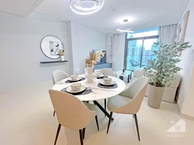 a white dining room with a white table and chairs at 2BR in Burj Crown l Pool Access & City Views in Dubai