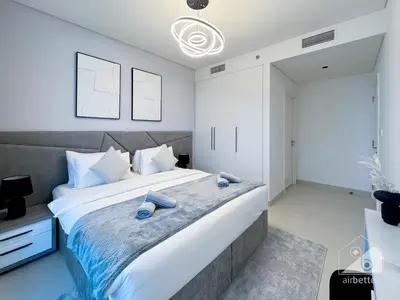 a bedroom with a large bed with white walls at 2BR in Burj Crown l Pool Access & City Views in Dubai