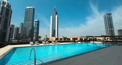 a swimming pool in a city with tall buildings at 2BR in Burj Crown l Pool Access & City Views in Dubai