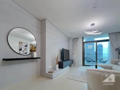 a living room with a couch and a mirror at 2BR in Burj Crown l Pool Access & City Views in Dubai