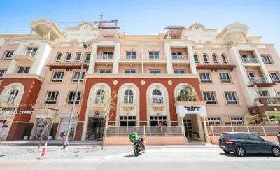 a building with a motorcycle parked in front of it at A chilled place JVC in Dubai