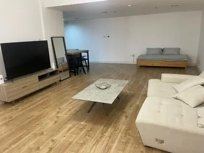 a living room with a couch and a flat screen tv at A chilled place JVC in Dubai