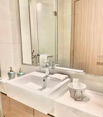 a white bathroom with a sink and a mirror at Dubai Galaxy in Azizi Riviera Luxury Studio in Dubai
