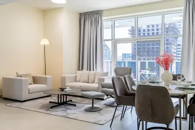 a living room with a table and chairs at Spacious apartment with Maid room in Dubai Marina I Marina Arcade in Dubai