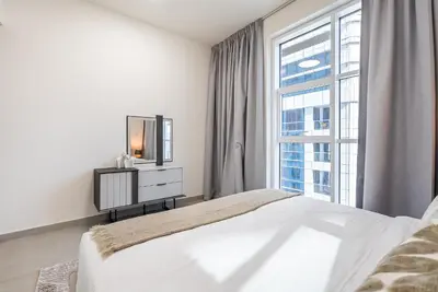 a bedroom with a bed and a tv and a window at Spacious apartment with Maid room in Dubai Marina I Marina Arcade in Dubai