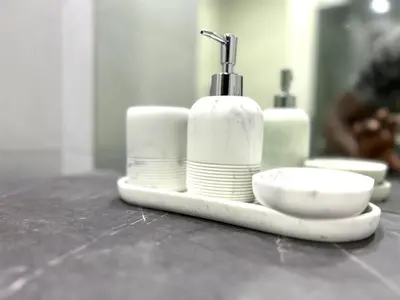 a plate with a soap dispenser and plates on a counter at ROYAL BEACH RESIDENCES 2 in Dubai