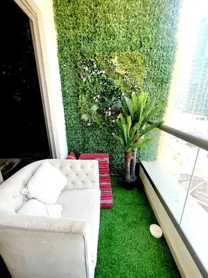 a living room with a white couch and a green wall at ROYAL BEACH RESIDENCES 2 in Dubai