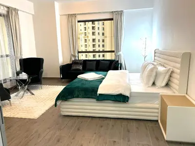 a bedroom with a large bed and a couch at ROYAL BEACH RESIDENCES 2 in Dubai
