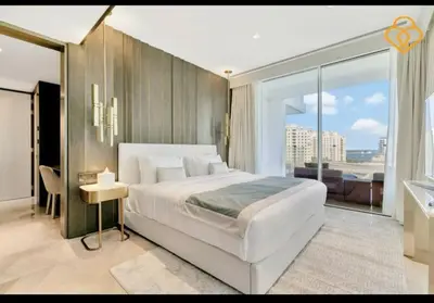 a bedroom with a large white bed and a large window at Five Palm Residences 2 Bedroom Apt in Dubai