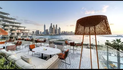 a balcony with tables and chairs and a view of the city at Five Palm Residences 2 Bedroom Apt in Dubai