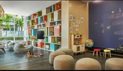 a childrens room with a large book shelf and chairs at Five Palm Residences 2 Bedroom Apt in Dubai