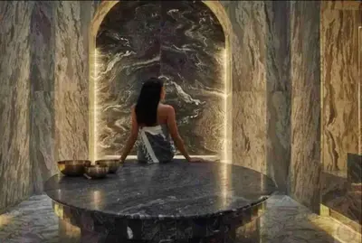 a woman sitting at a table in a room at Five Palm Residences 2 Bedroom Apt in Dubai