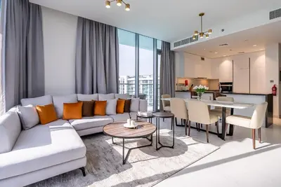 a living room with a couch and a table at 3BDR with Maid Room I District One I Spacious and Cozy in Dubai