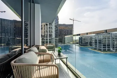 a balcony with a swimming pool on a building at 3BDR with Maid Room I District One I Spacious and Cozy in Dubai