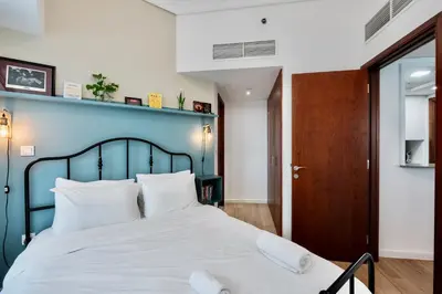 a bedroom with a large bed with a blue headboard at Next To Metro Unique 2bed Apt Wlarge Balcony in Dubai
