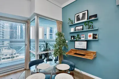 a dining room with a glass table and chairs and a large window at Next To Metro Unique 2bed Apt Wlarge Balcony in Dubai