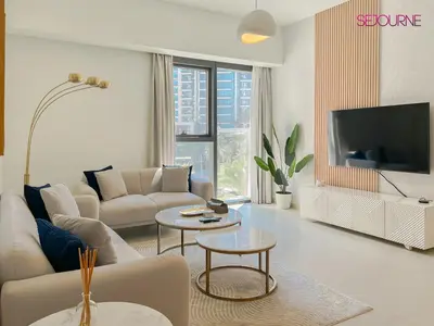 a living room with a couch and a tv at Brand New Luxurious 2BR ACT Towers Downtown in Dubai