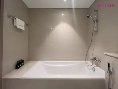 a white bath tub in a bathroom with a shower at Brand New Luxurious 2BR ACT Towers Downtown in Dubai
