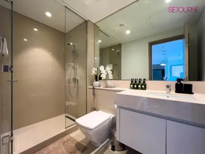 a bathroom with a toilet and a shower and a sink at Brand New Luxurious 2BR ACT Towers Downtown in Dubai