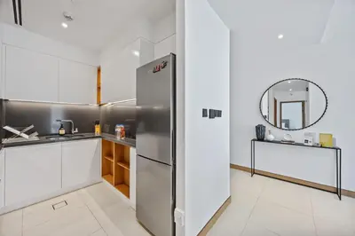 a kitchen with a refrigerator and a mirror at Hidden Gem, Waterfront Escape With Harbor View in Dubai