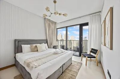 a bedroom with a large bed and a large window at Hidden Gem, Waterfront Escape With Harbor View in Dubai
