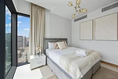 a bedroom with a bed and a large window at Hidden Gem, Waterfront Escape With Harbor View in Dubai