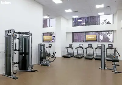 a gym with rows of tread machines in a room at bnbme - Premium 1BR Apt Balcony Pool Gym Parking Near Dubai Mall & Burj Khalifa in Dubai