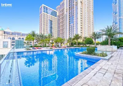 a swimming pool in a city with tall buildings at bnbme - Premium 1BR Apt Balcony Pool Gym Parking Near Dubai Mall & Burj Khalifa in Dubai