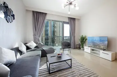 a living room with a couch and a tv at Elegant Waterfront 1BHK in Dubai Creek Harbour in Dubai