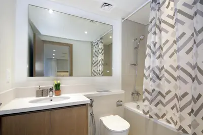 a bathroom with a sink and a toilet and a mirror at Elegant Waterfront 1BHK in Dubai Creek Harbour in Dubai
