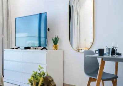 a living room with a tv on top of a dresser at HAVN - Studio in MYKA, Near Meaisem City Center in Dubai