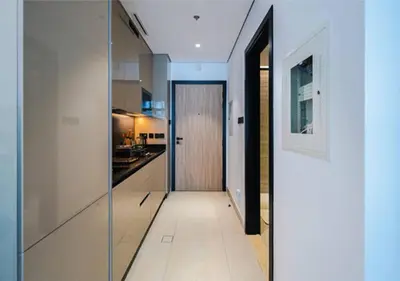 a kitchen with a glass door leading to a hallway at HAVN - Studio in MYKA, Near Meaisem City Center in Dubai