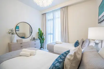 a bedroom with two beds and a mirror at Veluxa - Luxe 2Bed with Private Beach in Dubai