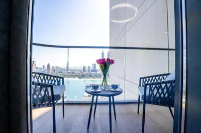 a table with a vase of flowers on a balcony at Veluxa - Luxe 2Bed with Private Beach in Dubai