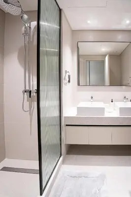 a bathroom with a shower and a sink at Veluxa - Luxe 2Bed with Private Beach in Dubai