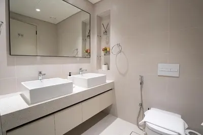 a bathroom with two sinks and a mirror and a toilet at Veluxa - Luxe 2Bed with Private Beach in Dubai