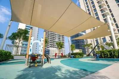 a playground with a large umbrella in a city at Veluxa - Luxe 2Bed with Private Beach in Dubai